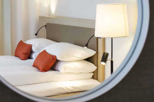 Bilde av seng i speil på superior rom på Scandic Meyergården.