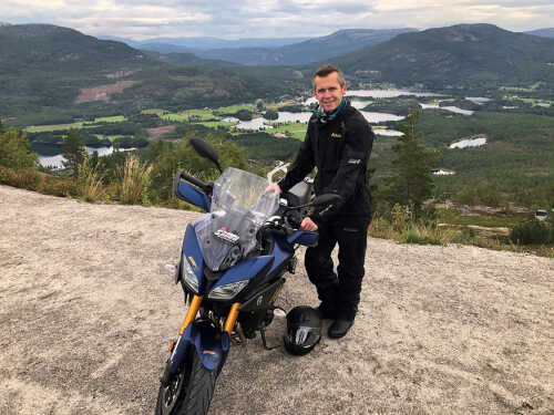 Bilde av Lars Arne som står ved motorsykkel med utsikt i Telemark.