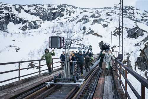 Bilde fra filminspilling "Kampen om Narvik", mennesker som løper på toglinje.