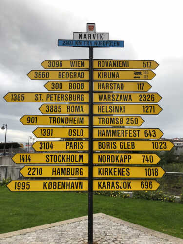 Skilt med mange steder i verden Narvik
