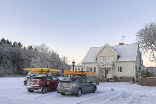 Bilde av 2 bilder med kajakk på taket foran Villa Bro med snø.
