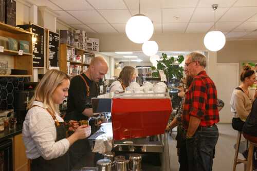 Bilde av deltakere som blir servert kaffe hos Munin Kaffehus.