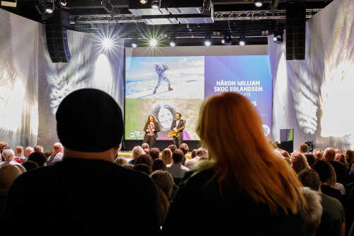 Bilde av publikum bakfra som ser på scenen med foredragsholdere.