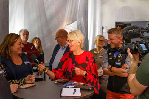 Bilde av programleder som intervjuer publikum.