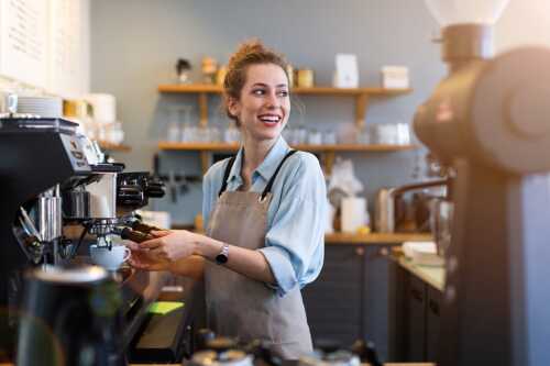 Bilde av ung dame som jobber og lager kaffe i kaffebar.